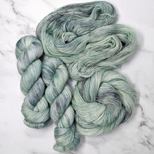 Load image into Gallery viewer, hand-dyed yarn in a variegated tonal colorway of icy blue, sea green and gray melting together like sunlight through water
