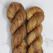 Load image into Gallery viewer, hand-dyed yarn in a speckled tonal colorway of warm browns generously dappled with earthy green and brown speckles
