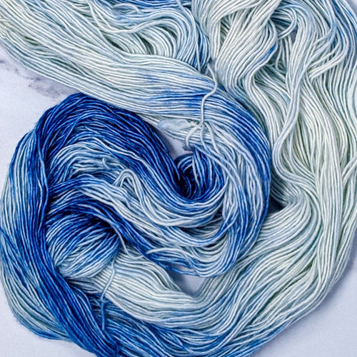 hand-dyed yarn in a variegated colorway of rich royal blue melting into pure white