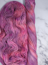 Load image into Gallery viewer, hand-dyed yarn in a variegated colorway of pink, peach and purple shades
