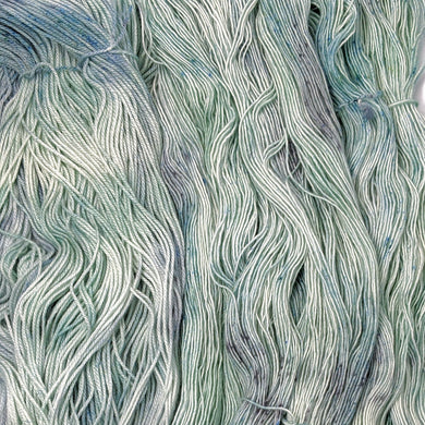 hand-dyed yarn in a variegated tonal colorway of icy blue, sea green and gray melting together like sunlight through water