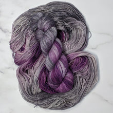 Load image into Gallery viewer, hand-dyed yarn in a variegated colorway of bursts of purple among waves of smokey gray
