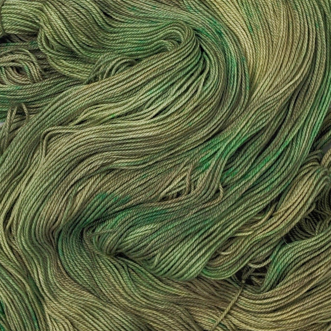 hand-dyed yarn in a variegated colorway of fully saturated shifting greens and browns