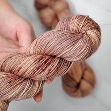 Load image into Gallery viewer, hand-dyed yarn in a variegated tonal colorway of rosey tonal browns with flashes of dark rose and chestnut brown
